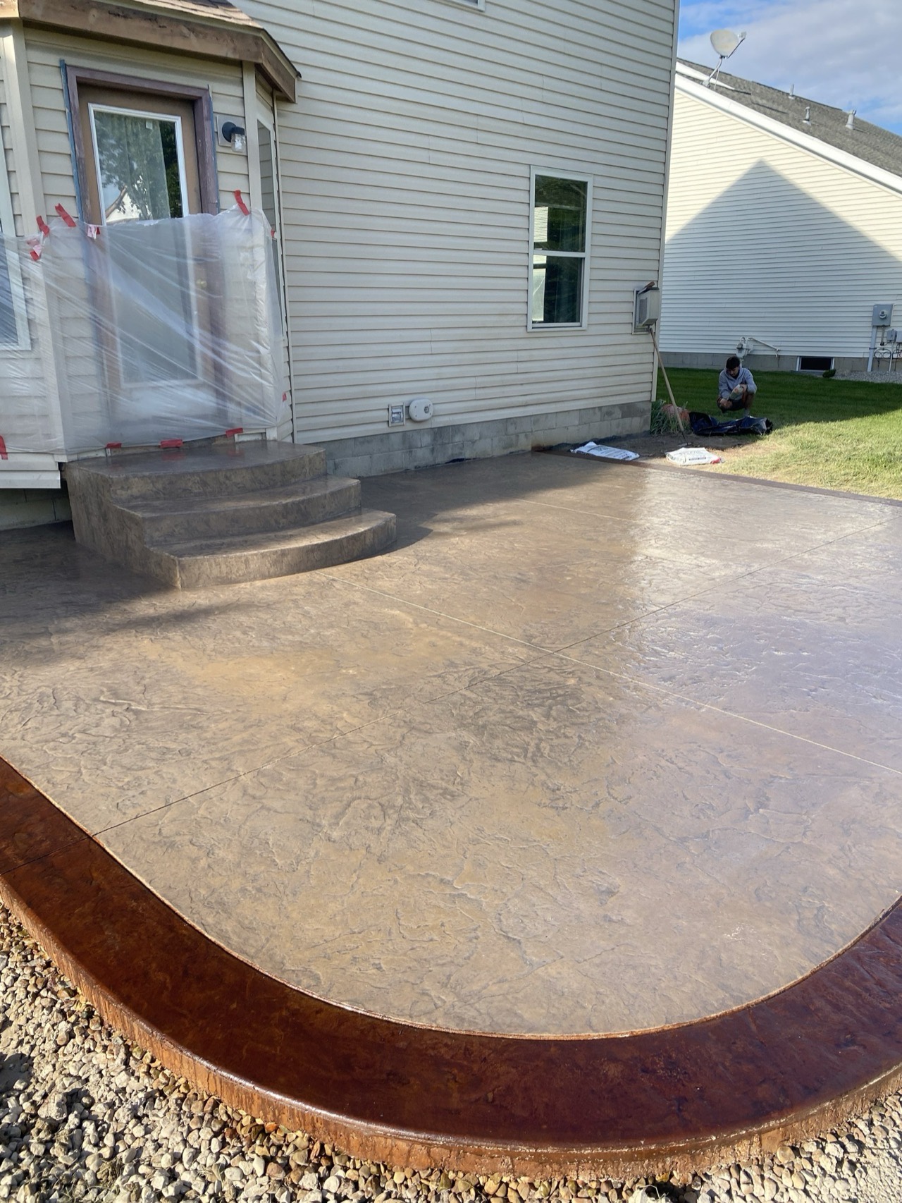 Stamped concrete patio with stained border and steps by O's Concrete